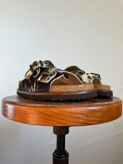 Botas Hasta La Muerte brown and white cowhide huaraches with cork footbed and Vibram sole handcrafted in León Mexico.